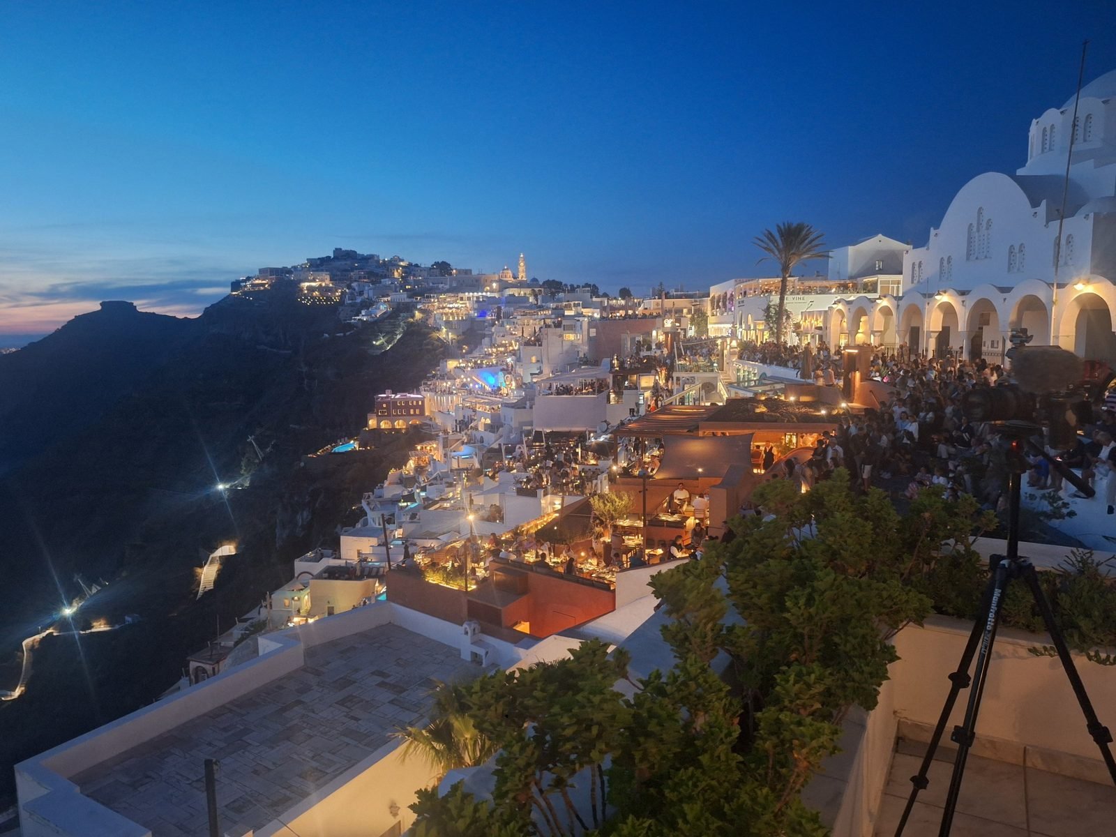 Ifestia festival night over the Fira caldera, seen from the crew's camera position at the Atlantis Hotel, 19 September 2026